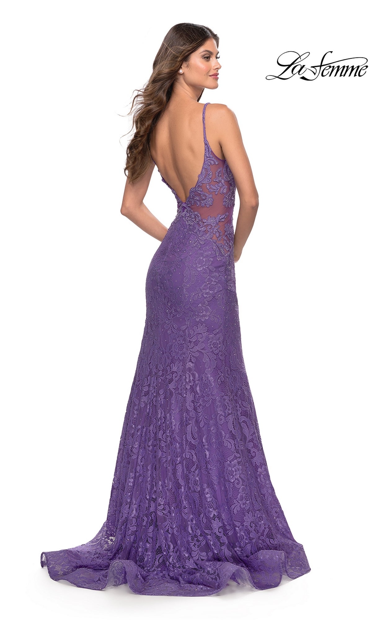 Woman in the La Femme 31512 long lace mermaid prom dress with thin straps, floor-length and backless in purple, stands looking over her shoulder against a white background.